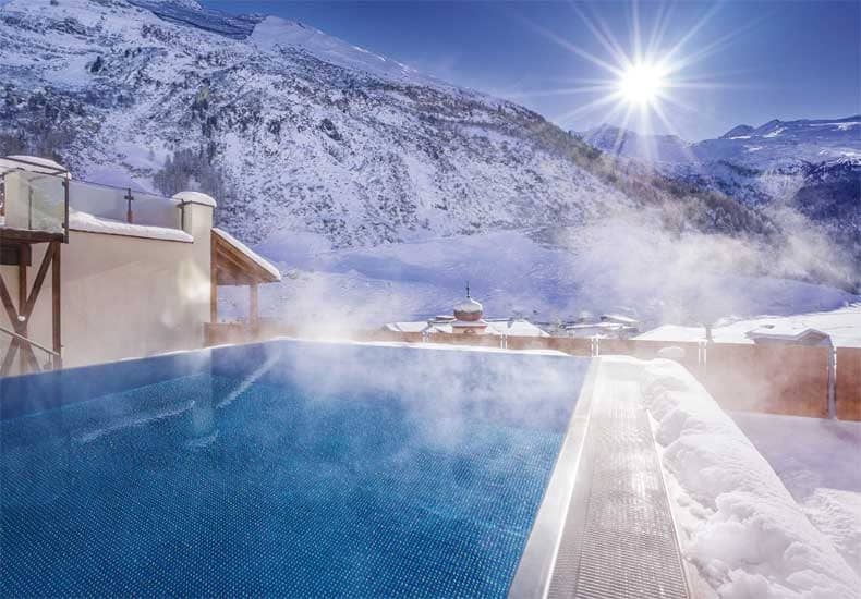 Vanuit het verwarmde buitenbad van 4 sterren hotel Klausnerhof heb je zicht op de Hintertuxer gletsjer en de bergen van het Tuxertal. © Hotel Klausnerhof